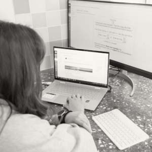Person working on a laptop with a monitor in front of them