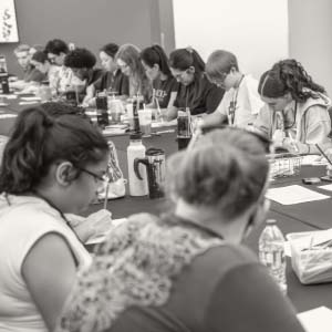 View down large table full of people in a class and taking notes