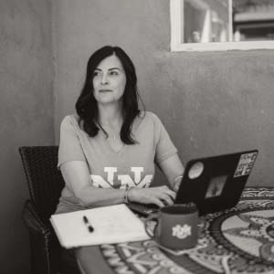 One person sitting with their laptop looking off in the distance